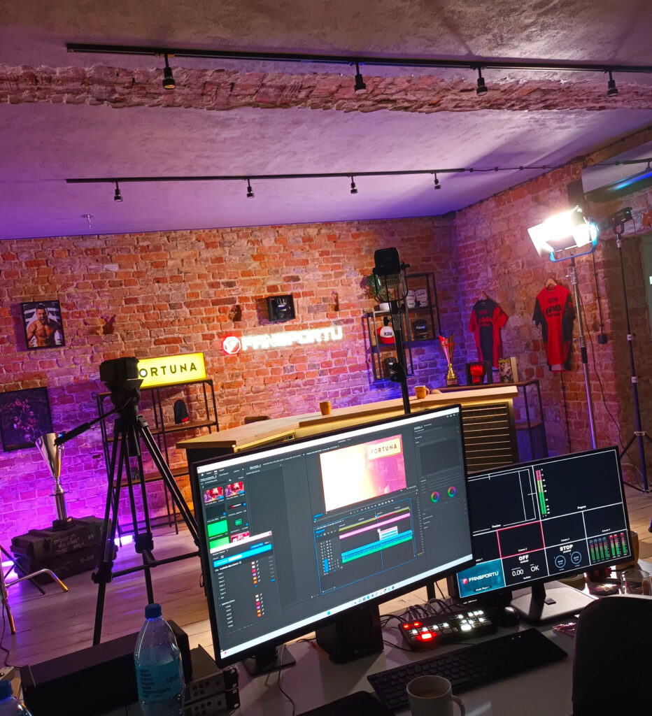 Wnętrze studia produkcyjnego Fansportu TV — ceglane ściany, oświetlenie sceniczne, stanowiska montażowe